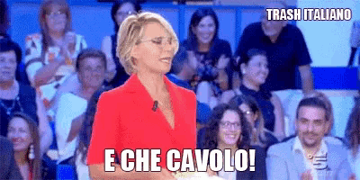 a woman in a red shirt is standing in front of a crowd and says trash italiano