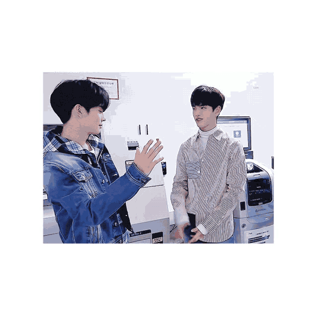 two young men are standing next to each other in front of a machine that says ' a ' on it