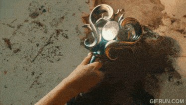 a gif from gifrun.com shows a person holding a sword in their hand