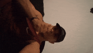 a man wearing a nike tank top and a hat that says high