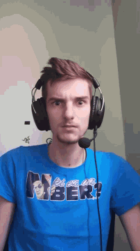 a man wearing headphones and a blue shirt that says ' amber '