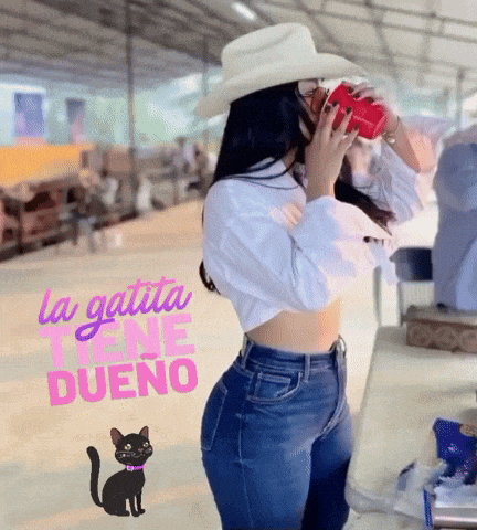 a woman in a cowboy hat is drinking from a red cup with the words la gatita tiene dueno written on the bottom