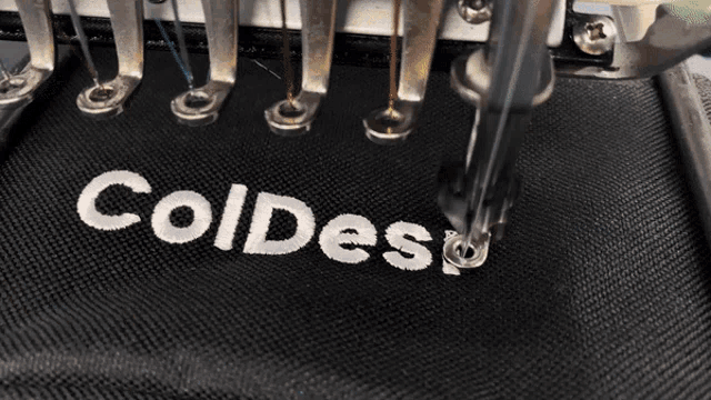 a machine is embroidery the word coldeso on a black cloth