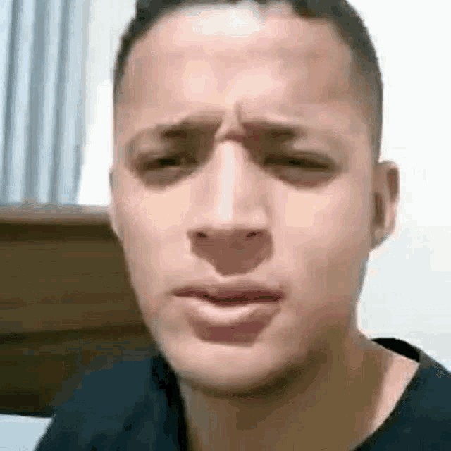 a young man is making a funny face with his eyes closed and his mouth open .