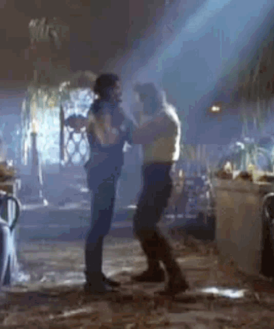 two men are standing next to each other in a room .
