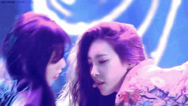 a couple of women are standing next to each other on a stage and looking at each other .