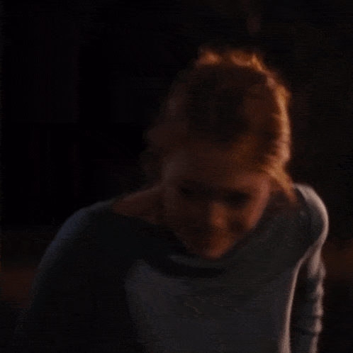 a woman with a surprised look on her face is covering her mouth with her hands