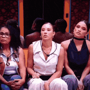 a group of women are sitting in a room with their hands folded