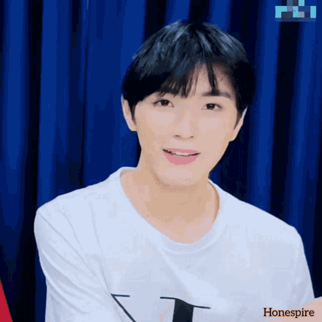 a young man wearing a white t-shirt with the word hone spire on the bottom