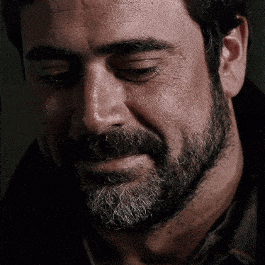 a close up of a man 's face with a beard and eyes closed .