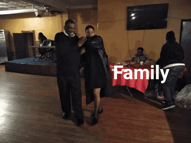 a man and a woman are dancing in a room with the word family on the bottom