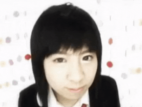 a young girl with short hair is wearing a school uniform and tie .