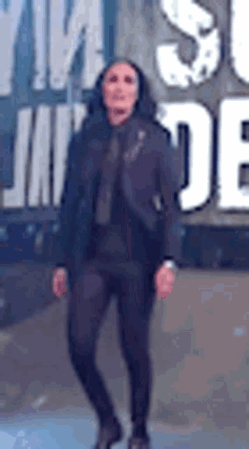a woman in a suit and tie is standing in front of a large sign that says `` suicide '' .
