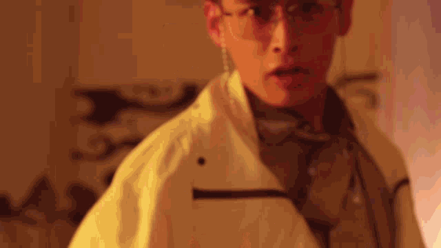 a man wearing glasses and a yellow jacket
