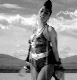 a black and white photo of a woman in a bikini dancing .