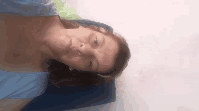 a woman in a blue shirt laying on a blue cushion
