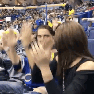 a group of people are clapping their hands in a crowd