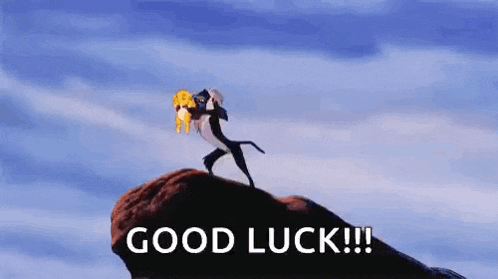 a lion from the lion king is standing on top of a rock carrying a baby .