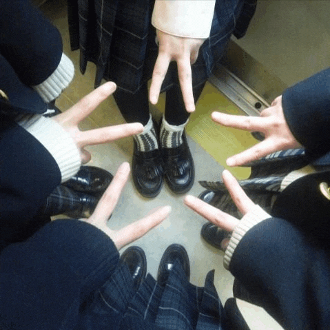 a group of people giving the peace sign with their hands