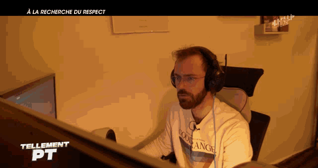 a man wearing headphones sits in front of a computer screen that says tellement pt on it