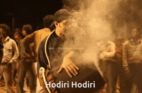 a man playing a drum in front of a crowd with the word hodiri on the bottom