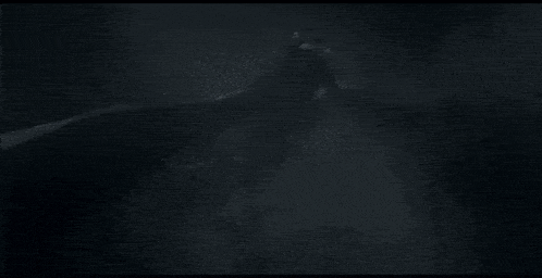 a person is walking through a foggy area with a light shining through the fog