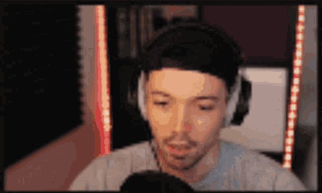 a man wearing headphones is talking into a microphone .