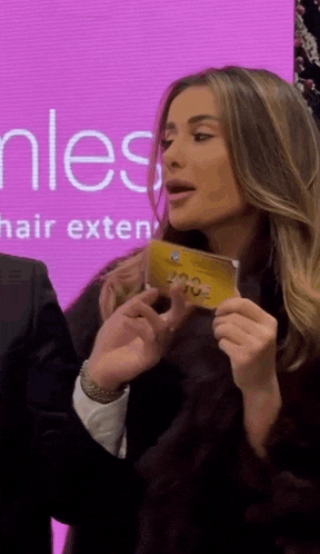 a woman holding a card that says love