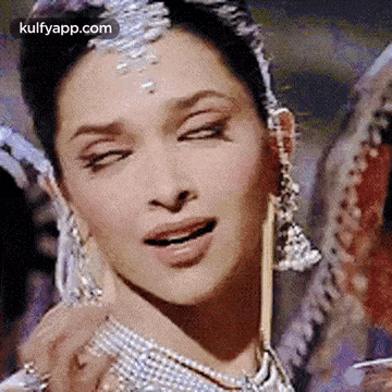 a close up of a woman 's face with her eyes closed and a necklace around her neck .