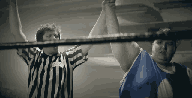 a referee wearing a black and white striped shirt with a name tag that starts with the letter r on it