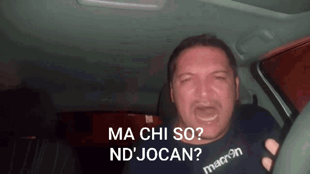 a man in a car with the words ma chi so nd jocan behind him