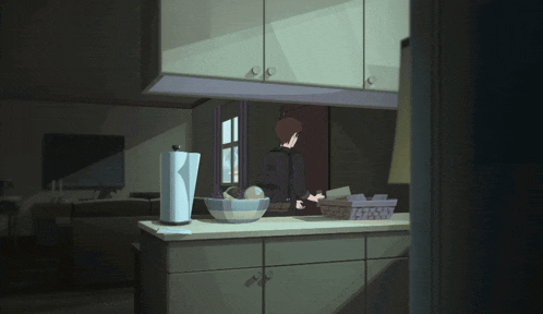 a kitchen with a paper towel holder and a bowl of fruit on the counter