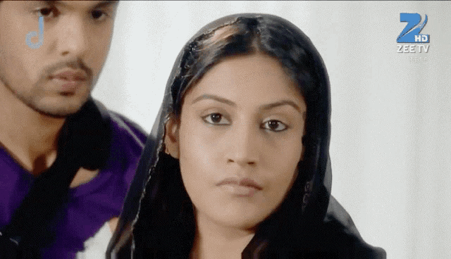 a man and a woman are standing in front of a screen that says zee tv on it