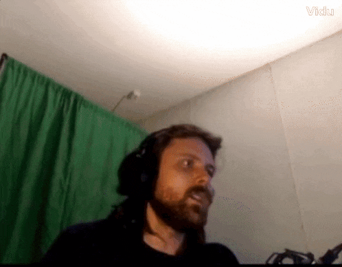 a man wearing headphones in front of a green screen