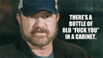 a man with a beard wearing a hat says " there 's a bottle of old " fuck you " in a cabinet