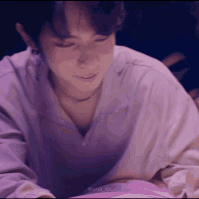 a close up of a person 's face with a purple shirt on .