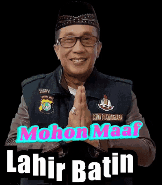 a man wearing glasses and a hat with the words mohon maaf lahir batin on the bottom