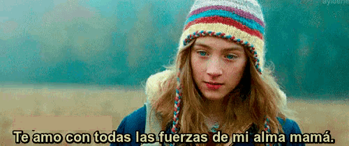 a girl wearing a knitted hat with the words te amo con todas las fuerzas de mi alma mama written below her