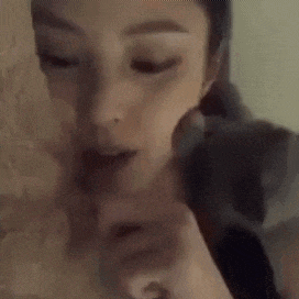 a close up of a woman holding a rabbit on her shoulder