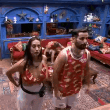 a man and a woman are standing next to each other in a living room with a couch .