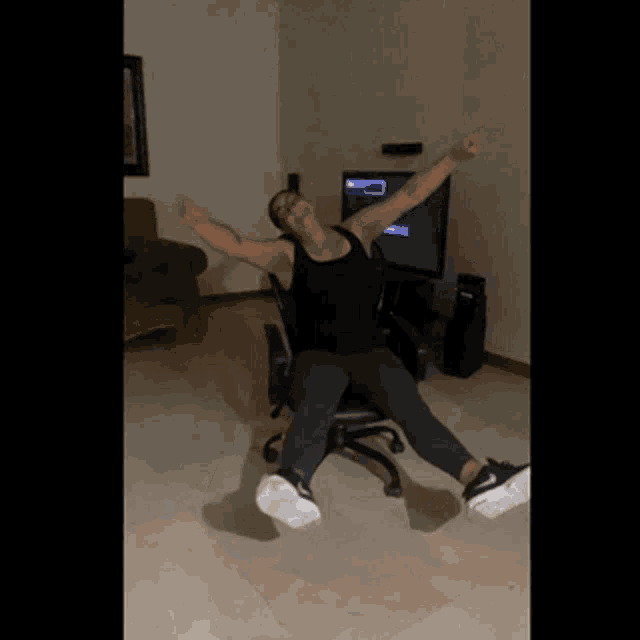 a man is sitting in a chair with his arms outstretched