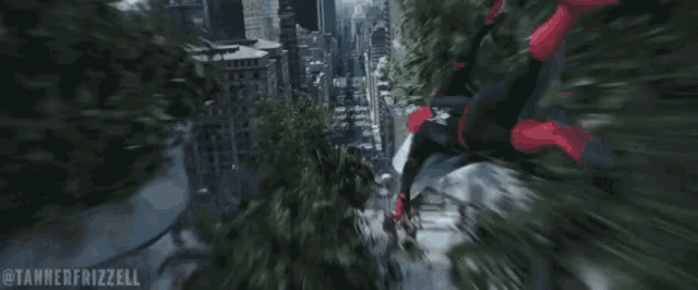 a man in a spiderman costume is flying through the air in a city