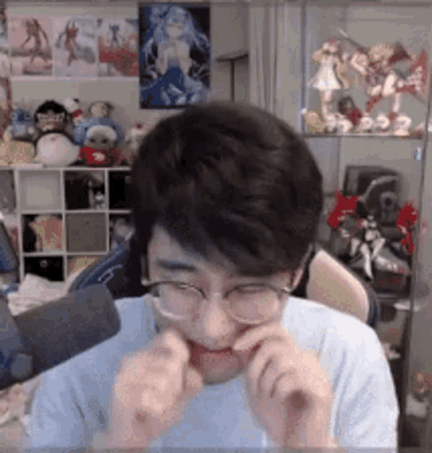a man wearing glasses is making a funny face in front of a shelf full of stuffed animals
