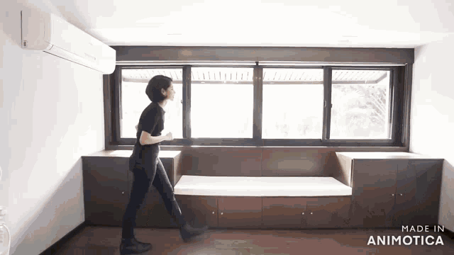 a woman walking in front of a window with the words made in animatica on the bottom right