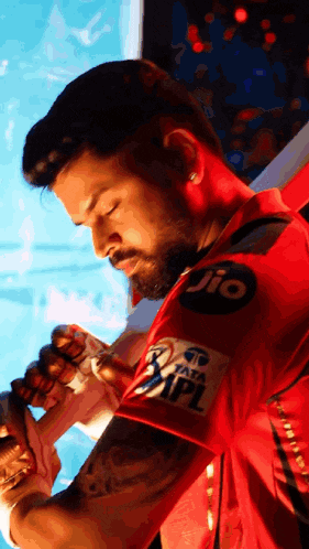 a man in a red shirt with jio written on the sleeve