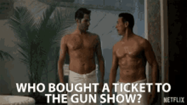 two shirtless men are standing next to each other in a bathroom and talking about a gun show .