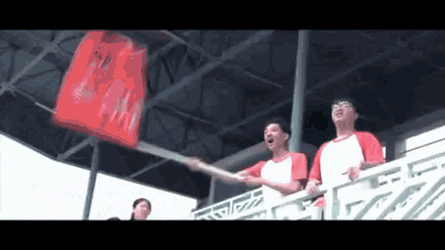 a man in a red shirt is holding a flag that says ' nm ' on it