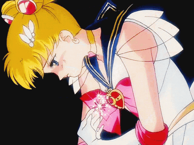 a girl in a sailor moon costume is holding a pink heart shaped necklace