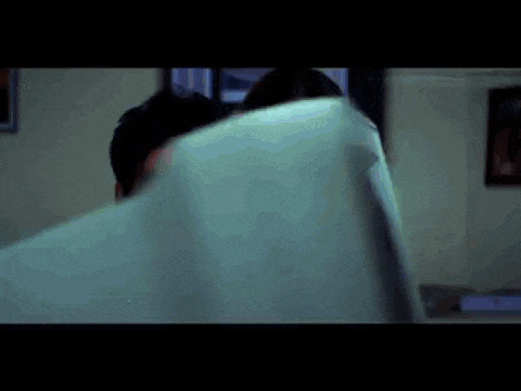 a man and a woman are looking at something in a room