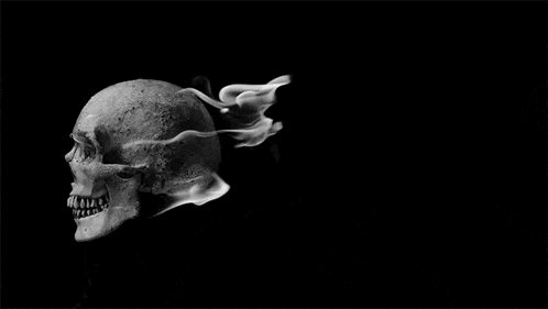 a black and white photo of a skull with fire coming out of it .